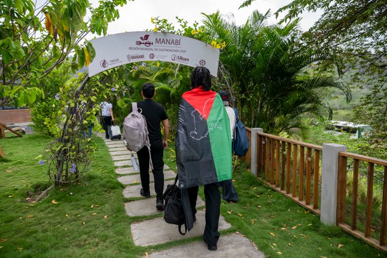 Participants arriving along the path, under the Manabí arch.