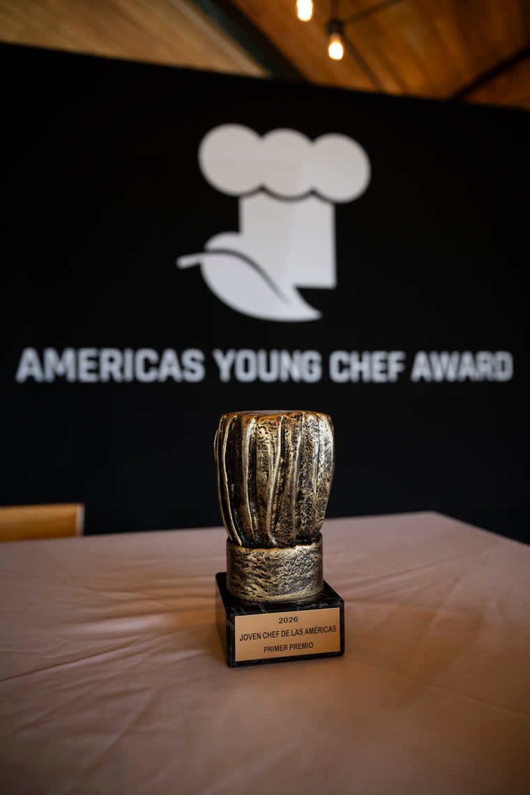 The Americas Young Chef Award trophy, in front of the Americas Young Chef Award logo.