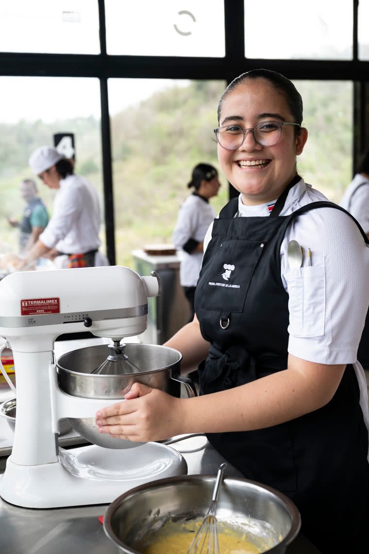 A contestant smiles beside her stand mixer.
