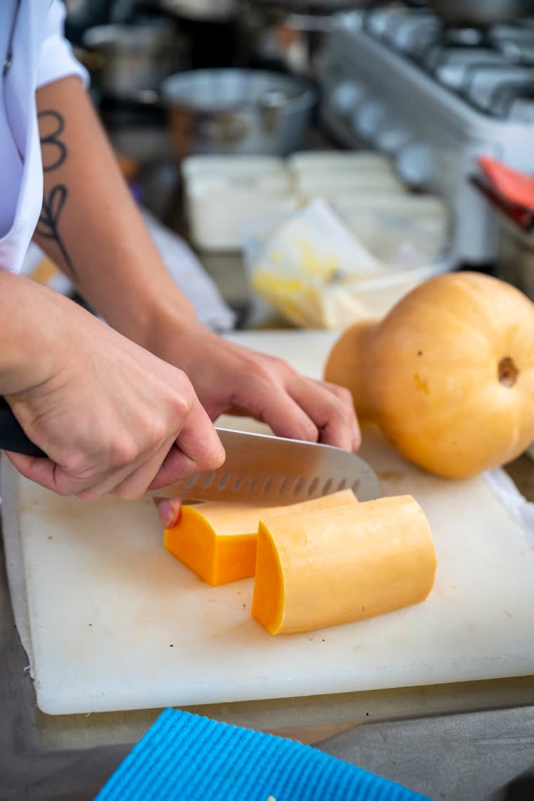 Squash cut into thick slices on a white board.