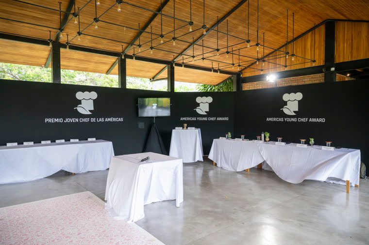 The competition hall before the test, with the jury tables and the brand backdrop.