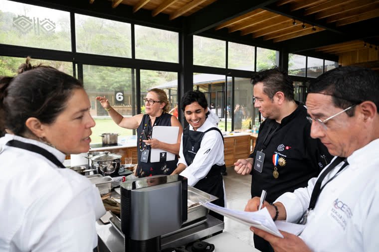 Evaluators and staff gather around a contestant’s station during the test.