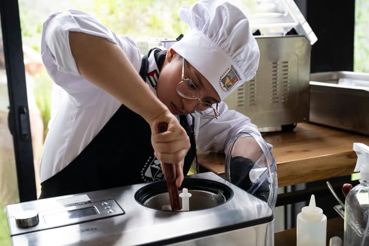 A contestant works a preparation in an ice cream machine.