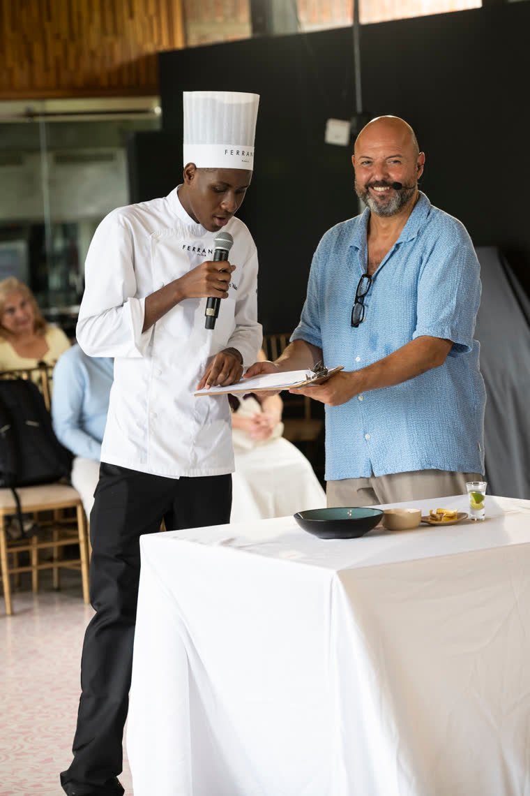 A chef presents his dish with a microphone next to the host.
