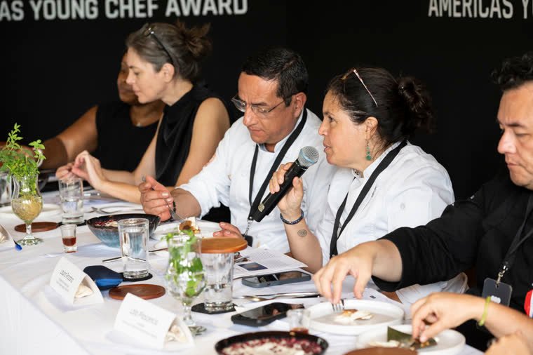 Judges taste and comment while one of them speaks into the microphone.